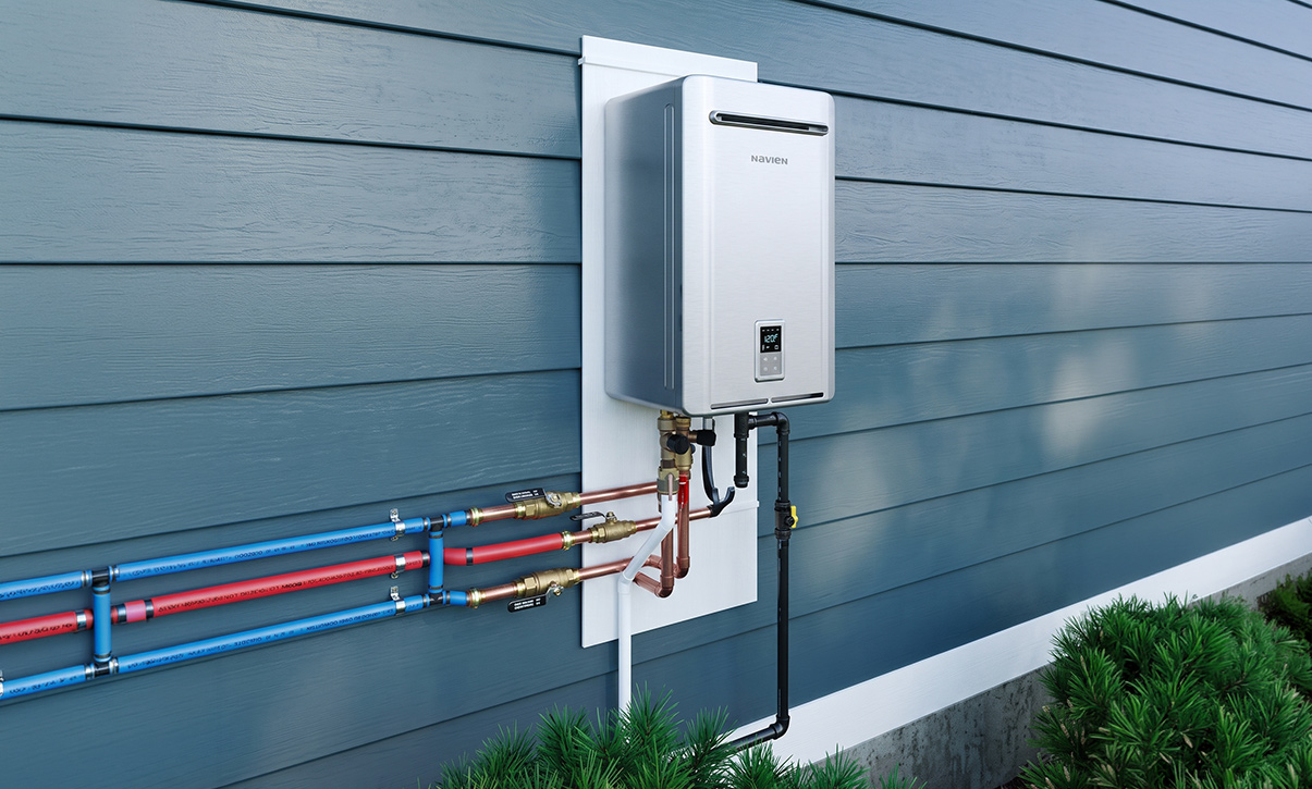 Wall-mounted gas geyser installed outdoors, with hot and cold water lines, isolation valves and the gas supply line neatly run into the unit
